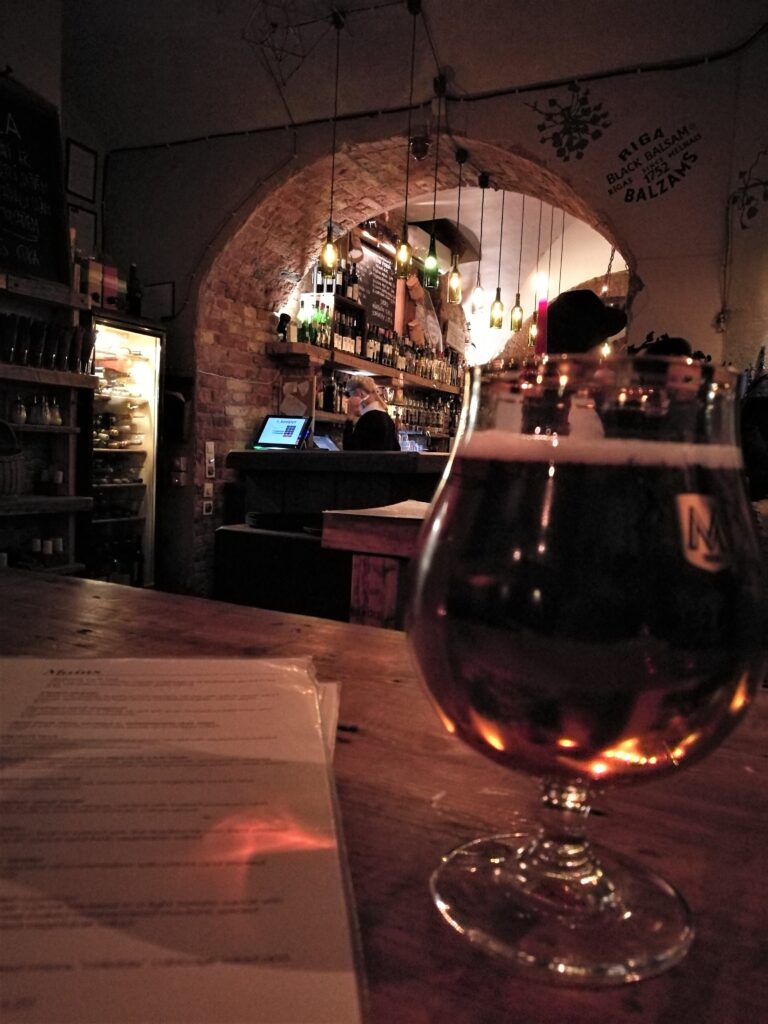 A beer on a table at Folkklubs Ala Pagrabs , the bar seen behind.