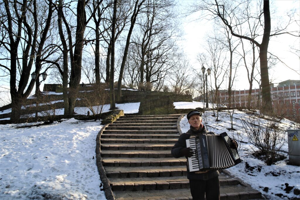 A man playing the accordion in the Bastejkalns park.