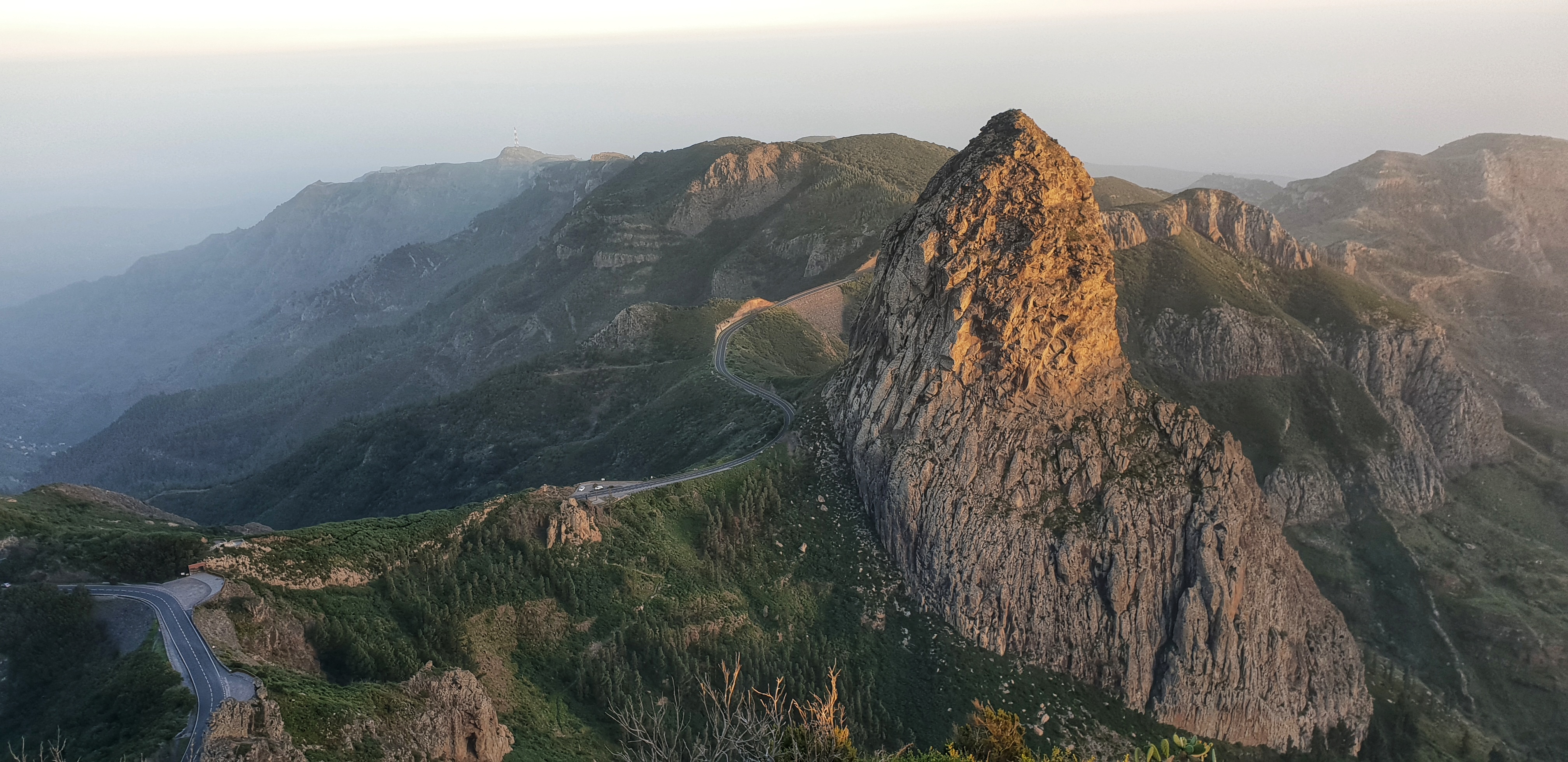 A winding road and a large rock formation in sunset on La Gomera.