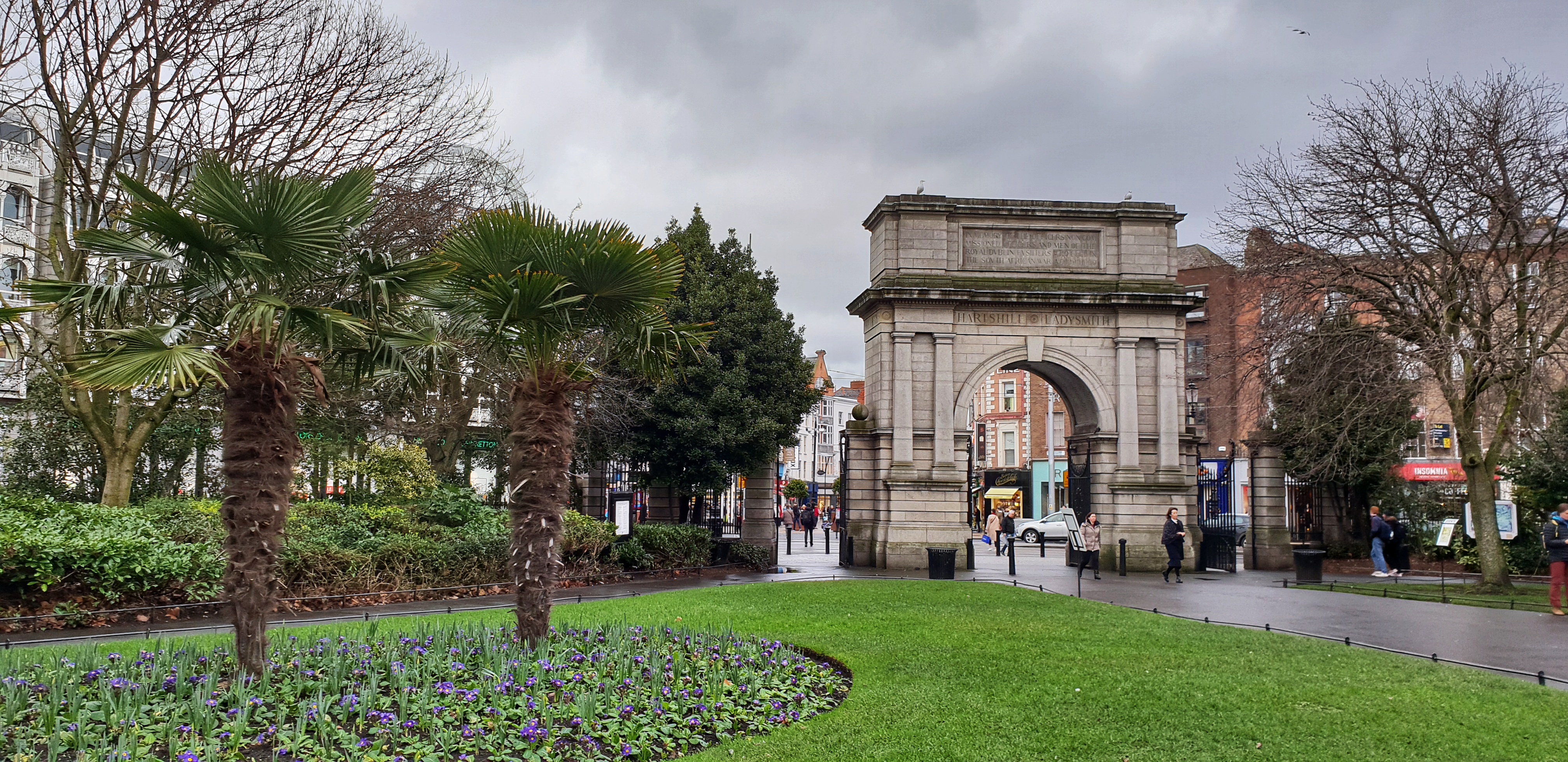 Fuslier's Arch by St. Stephens Green with palm trees and green fields on a gloomy February day