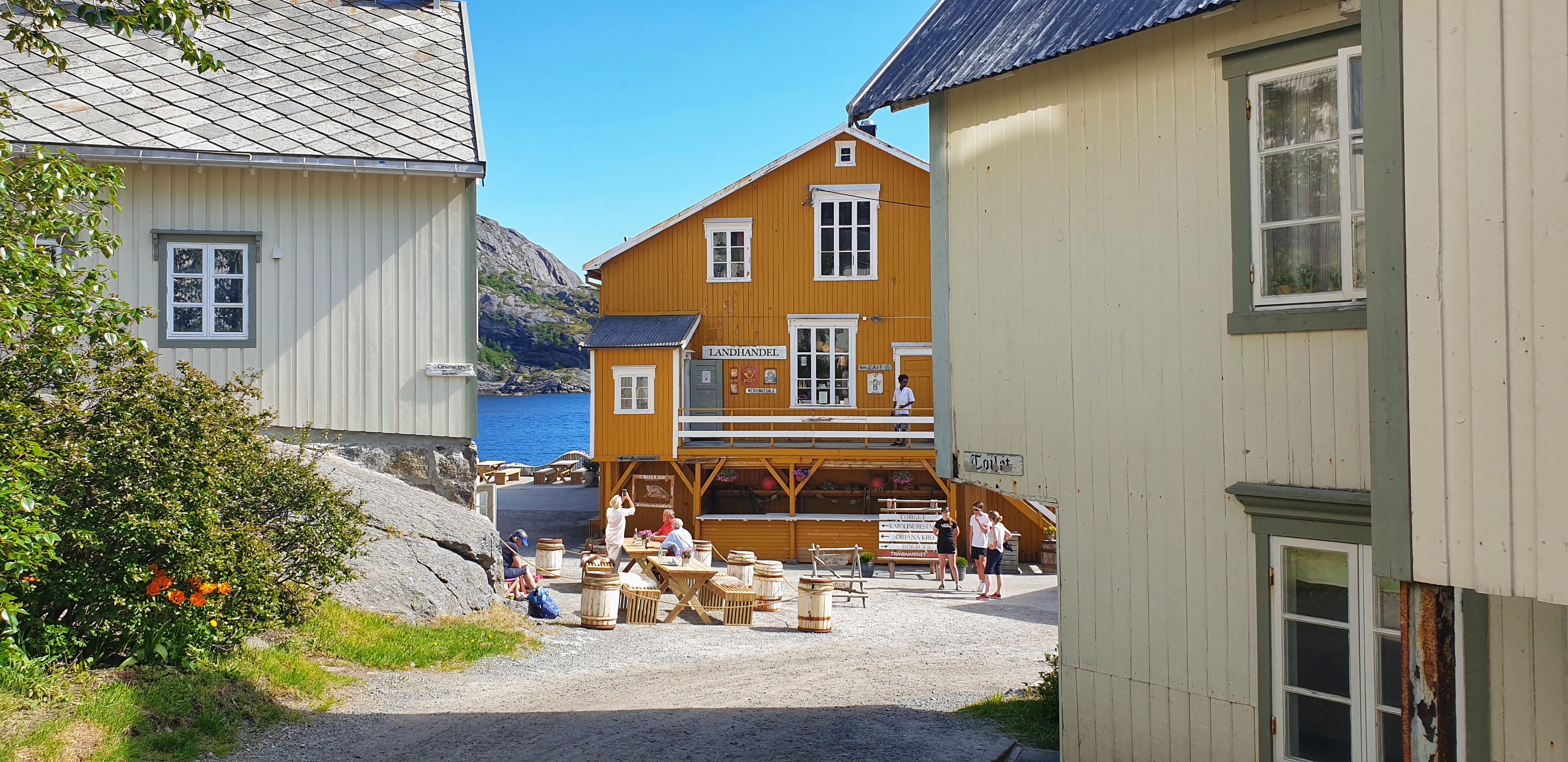 An outdoor café between old white and yellow houses in Nusfjord.
