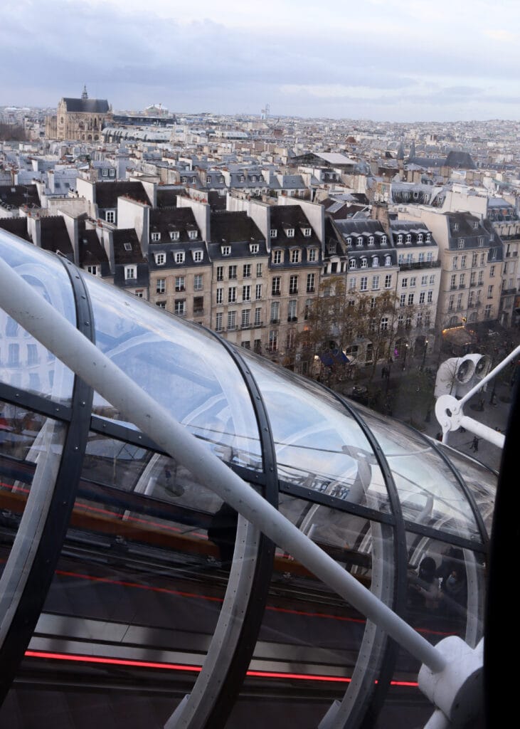 Escalators on the outside of Centre of Pompidou. Paris behind.