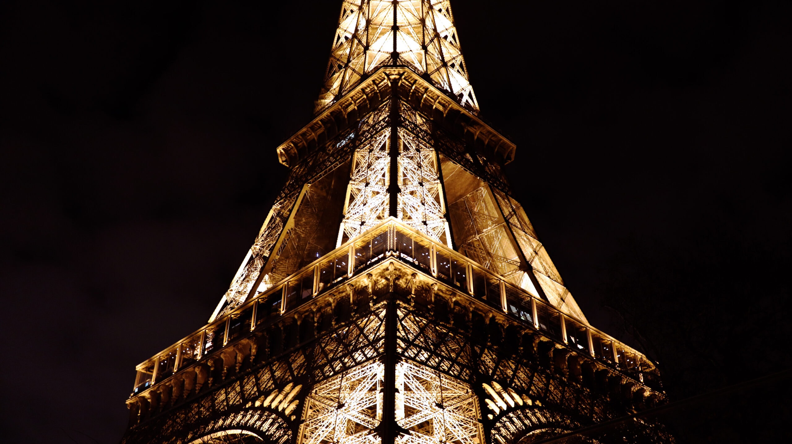 Close up of a part of the Eiffel Tower towards a dark December sky.