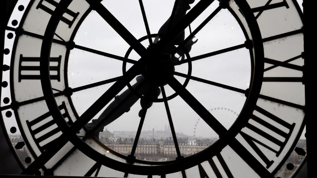 View of Paris in rainy weather through a clock.