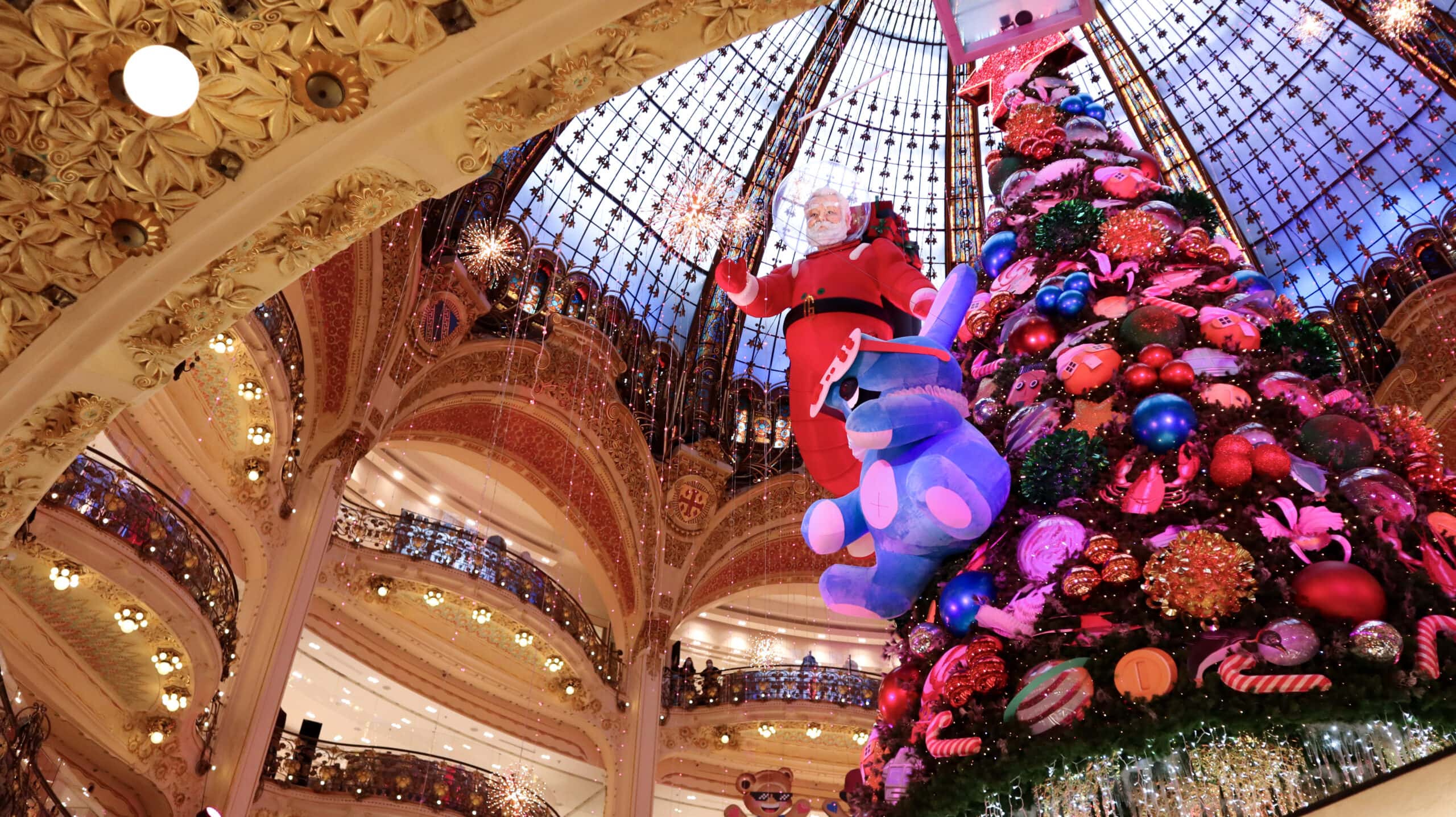 Christmas decorations hanging from the ceiling inside the historica Galeries Lafayette.