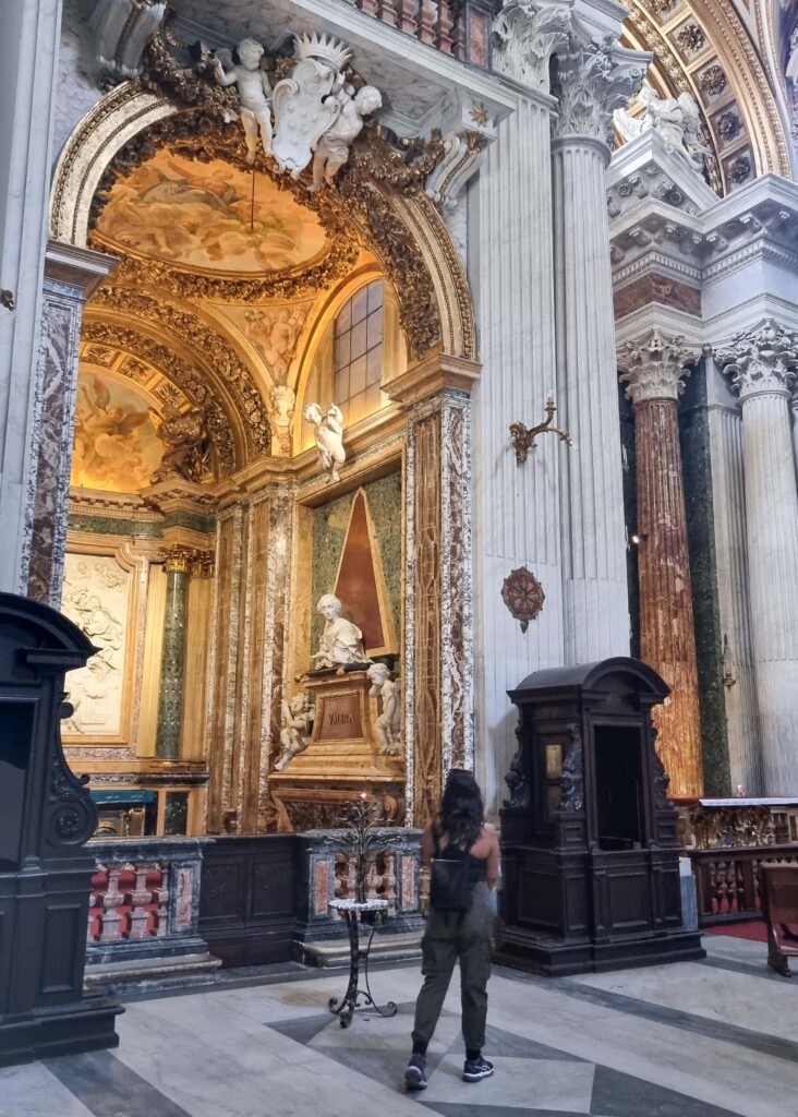 A woman seen from the back looking at ornaments in a church.