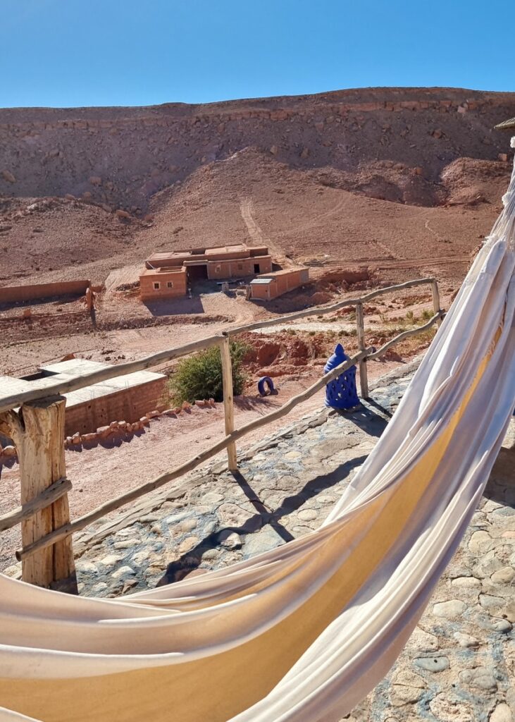 A hammock in Ait Ben Haddou seen from Riad Paradise of Silence with a small farm in the distance.