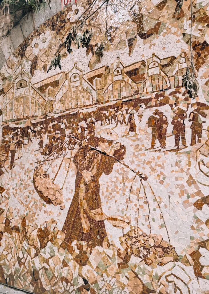 A mosaic on the wall on phung Hung Street.