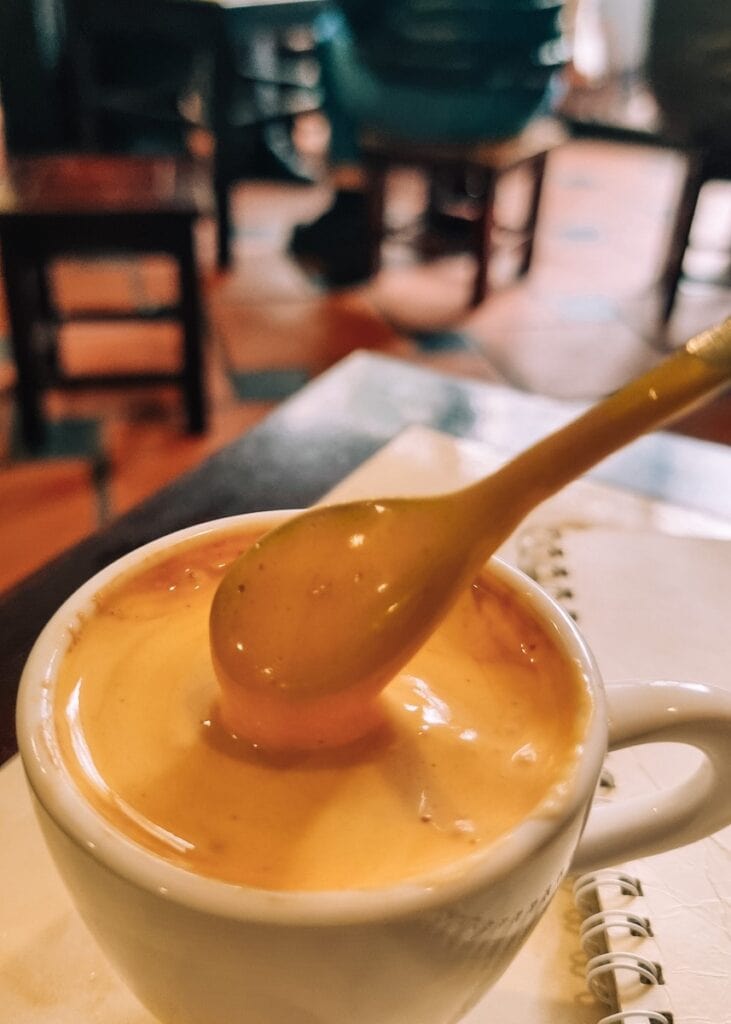 A spoon stirring in a cup of egg coffee in Hanoi.