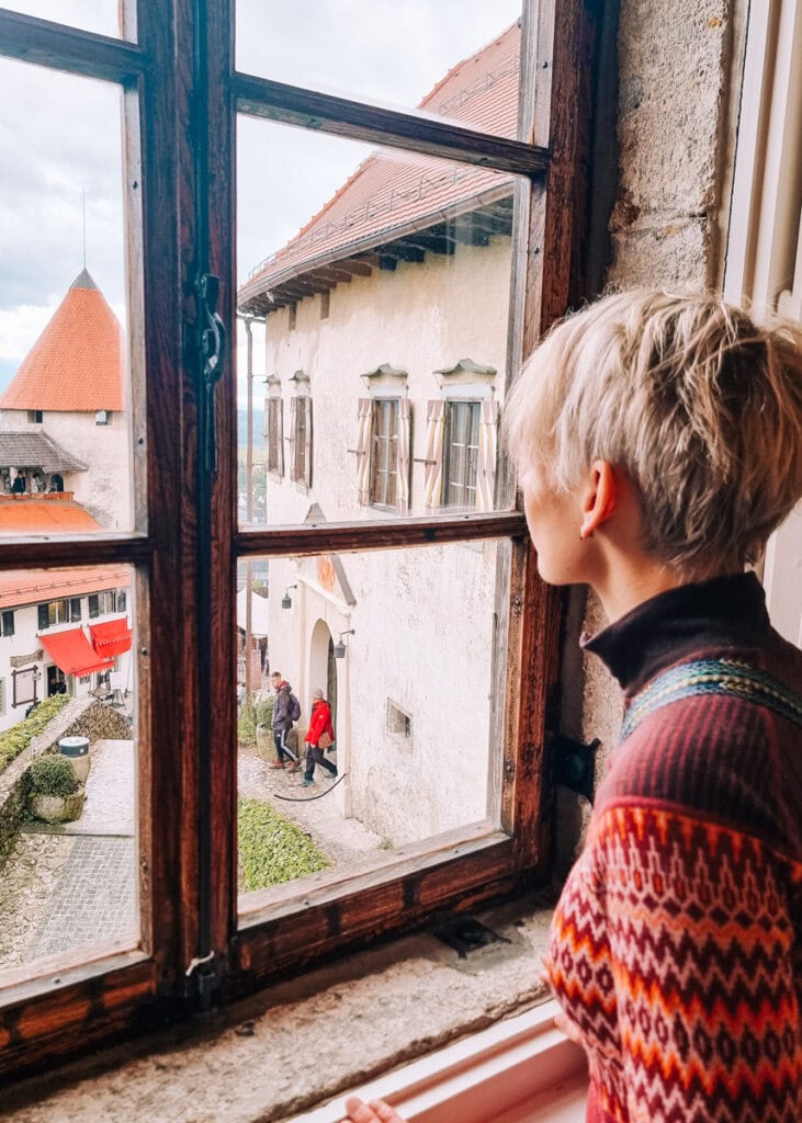 A woman looking out ofthe window from Bled Castle.