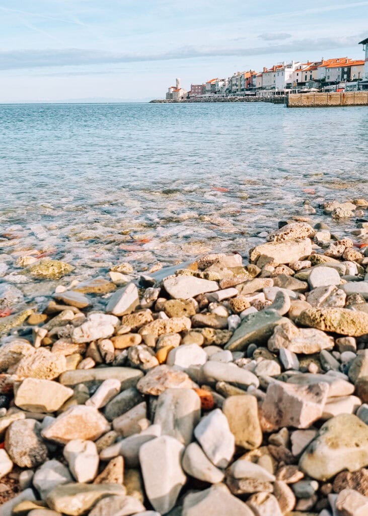 View of Piran from the beach. Pebbles in front.