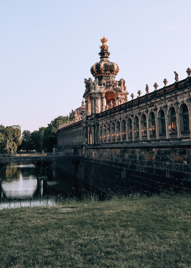 Exterior photo of Dresden's Zwinger Palace in golden morning light.