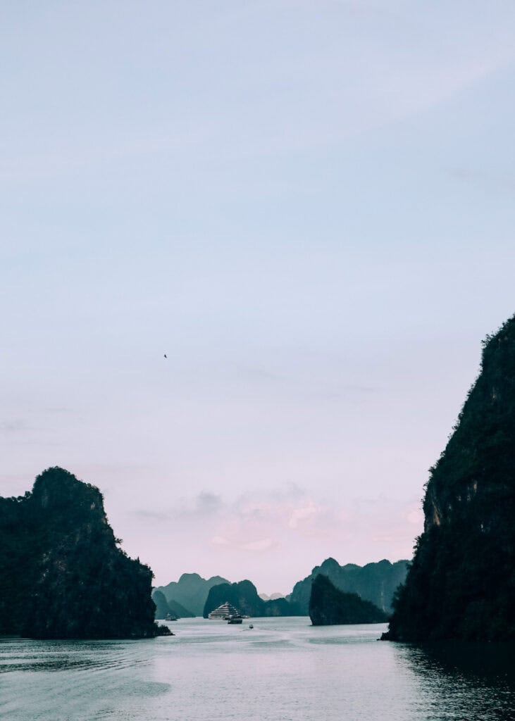 Photo of limestone karsts and some boats on Halong Bay.