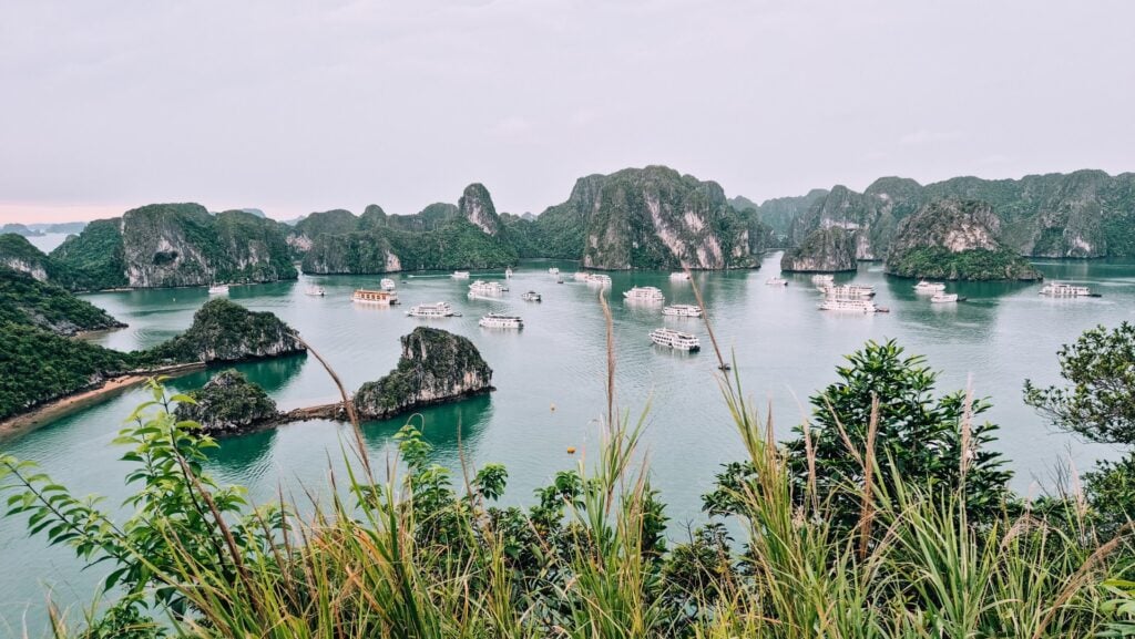 View from the viewpoint at Ti Top Islands. Many cruise ships anchored in Halong Bay surrounded by limestone karsts.