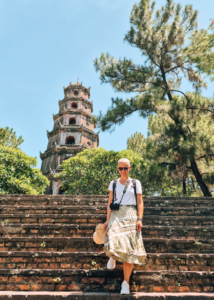 A woman walking down the stairs in front of the Thien Mu Pagoda in Hue.