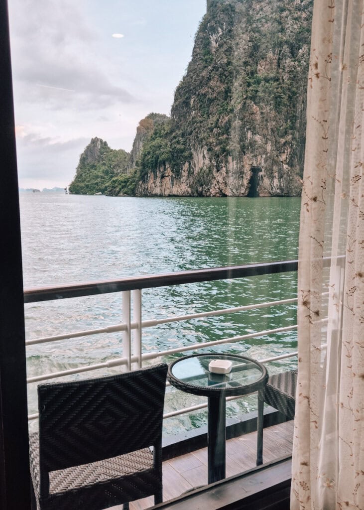 The balcony of a cabin on a MilaLux cruise seen from inside. Typical Halong scenery outside.