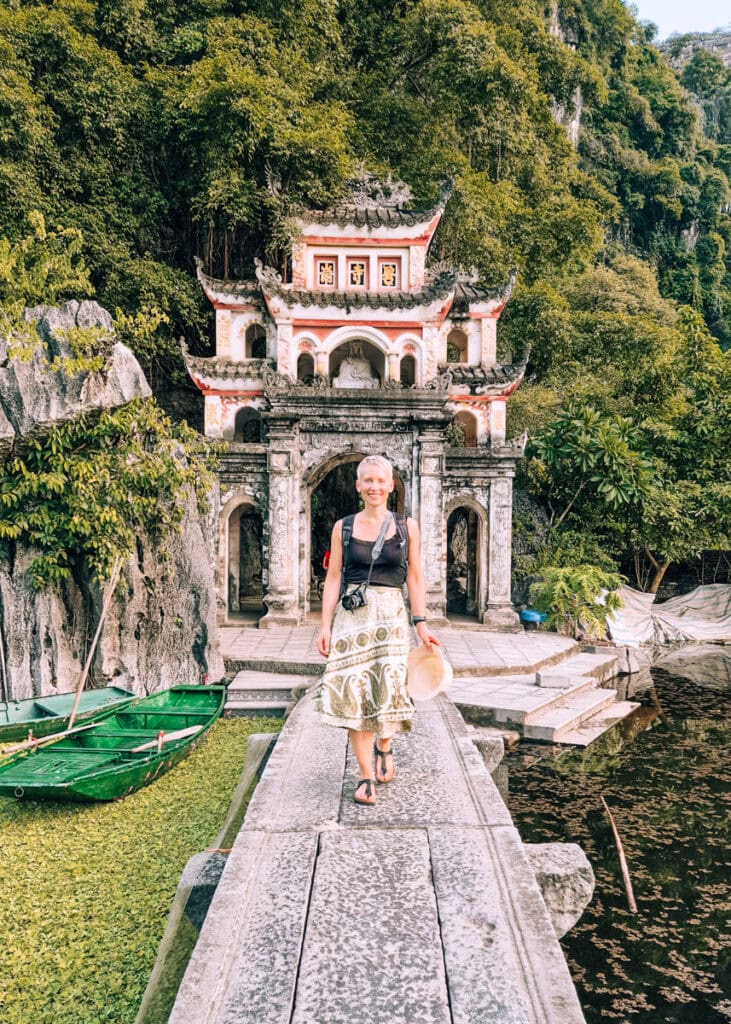 A woman walking on the bridge in front of the Bich Dong Pagoda in Ninh Binh.