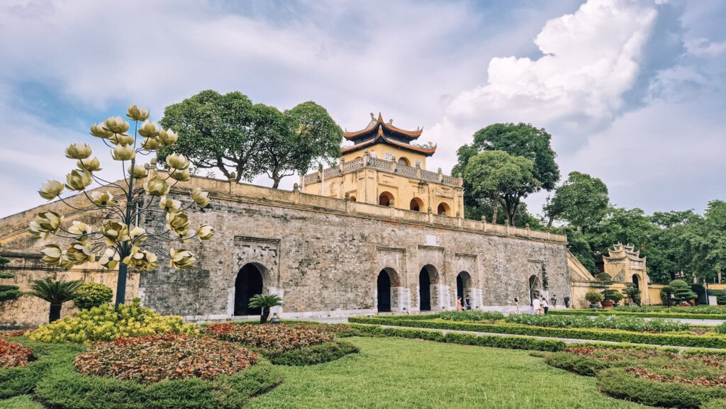 Exterior shot of an ancient building inside the Imperial Citadel in Hanoi with the garden in front.