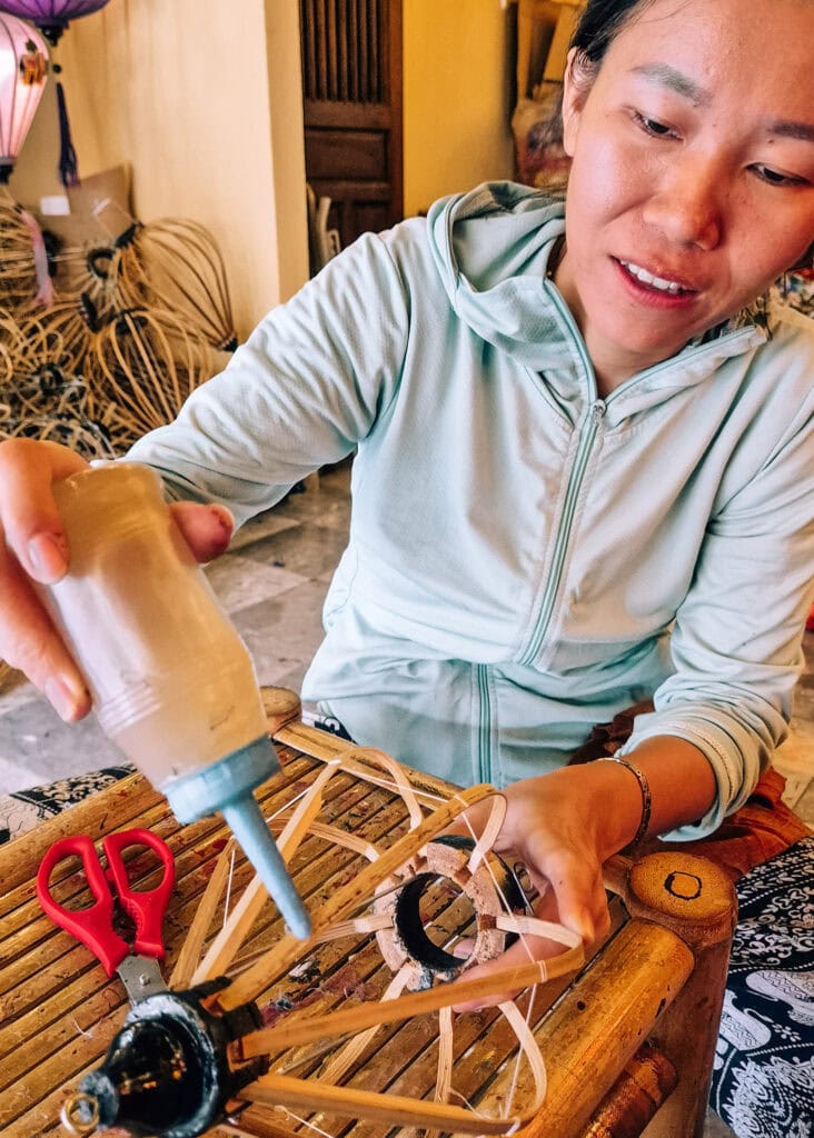 Lantern making in Hoi An, a woman putting glue on a frame.