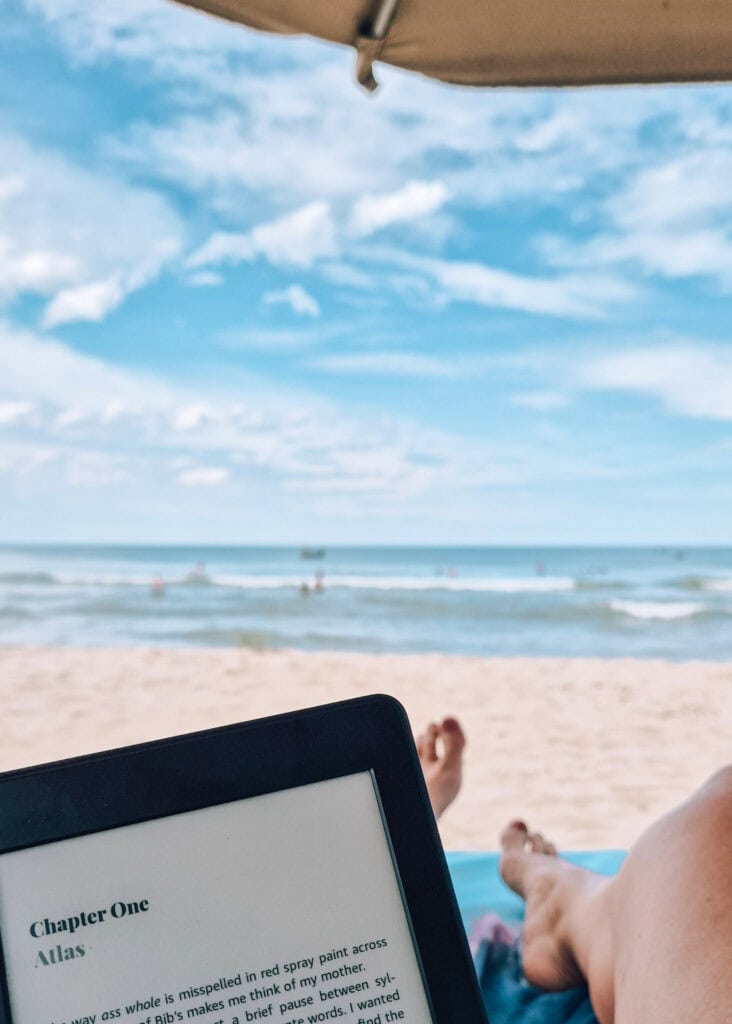 A kindle and legs on a sunbed on An Bang Beach.
