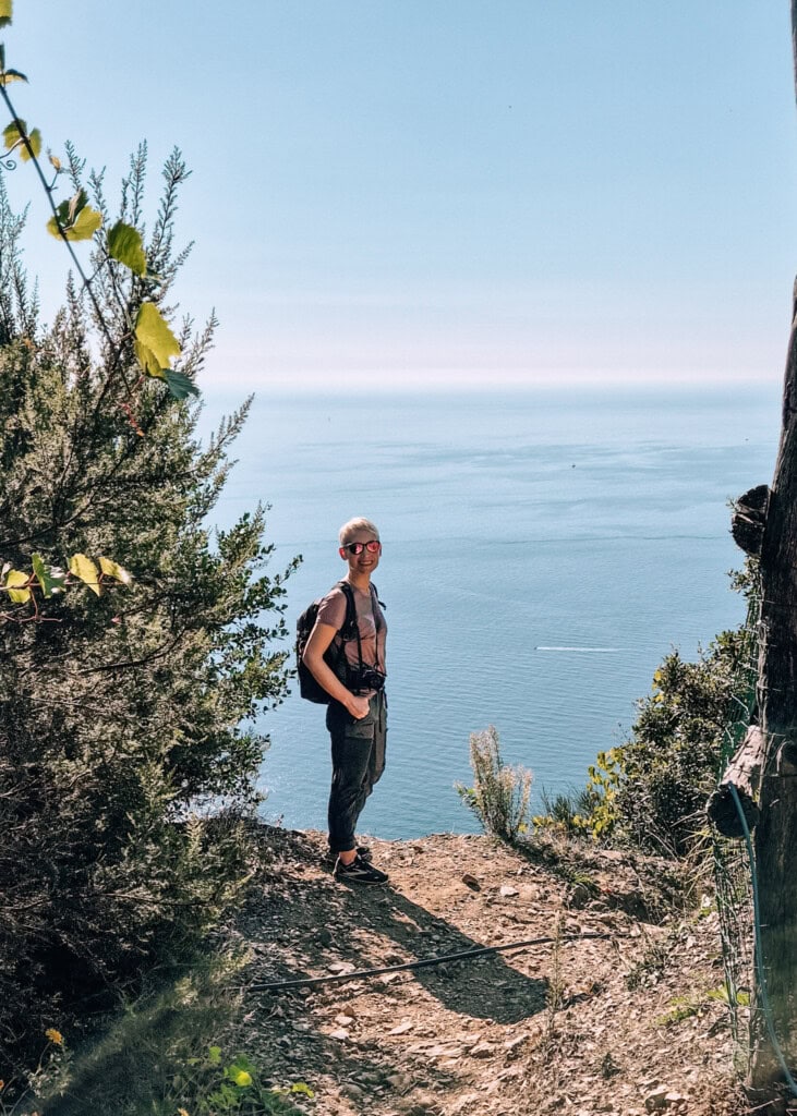 Me standing on a viewpoint along a trail in Cinque Terre with the Ligurian Sea behind me.