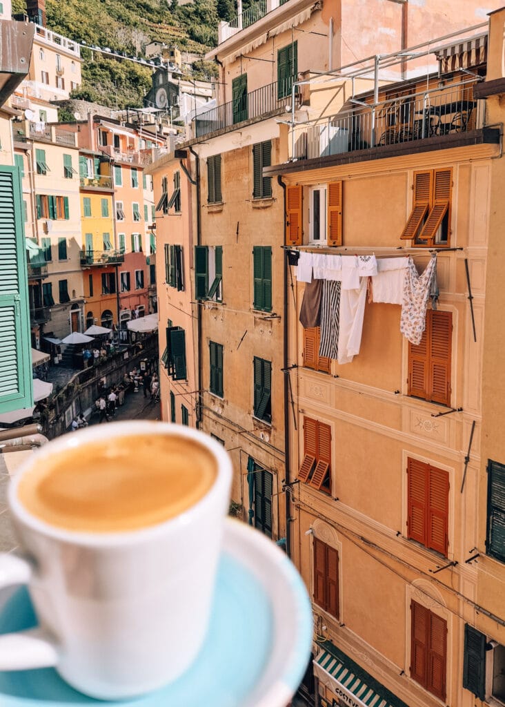 A cup of coffee on a balcony with views to the main street in Riomaggiore below.