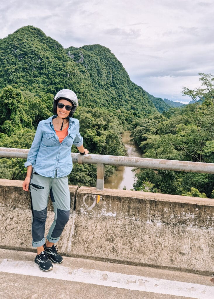 Me (Anne) standing on a bridge, smiling at the camera while wearing a motorbike helmet in Phong Nha National Park.