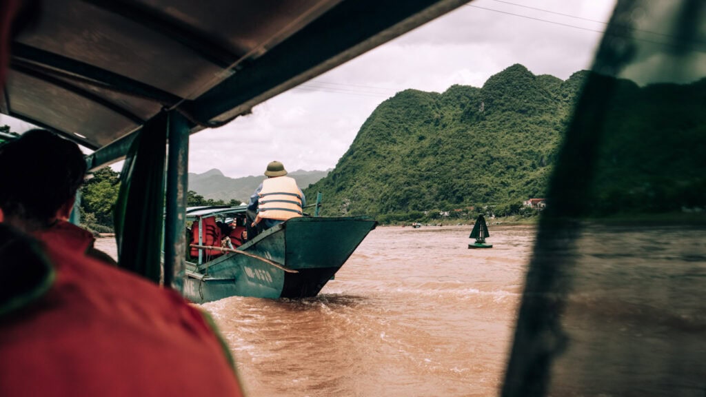 River views from a typical shuttle boat in Phong Nha. Another boat with tourists in front.