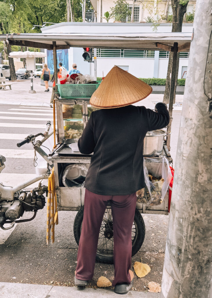 A woman selling food from a small cart on the streets of Ho Chi Minh City.