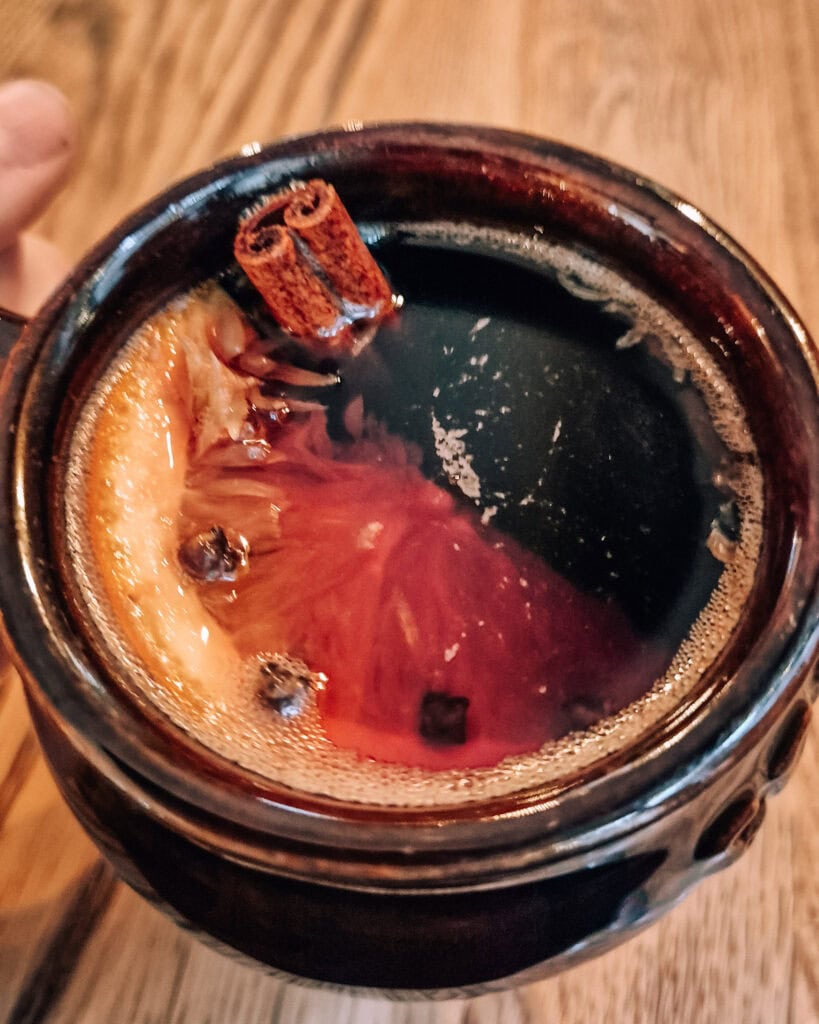 A cup of mulled wine with orange and cinamon.