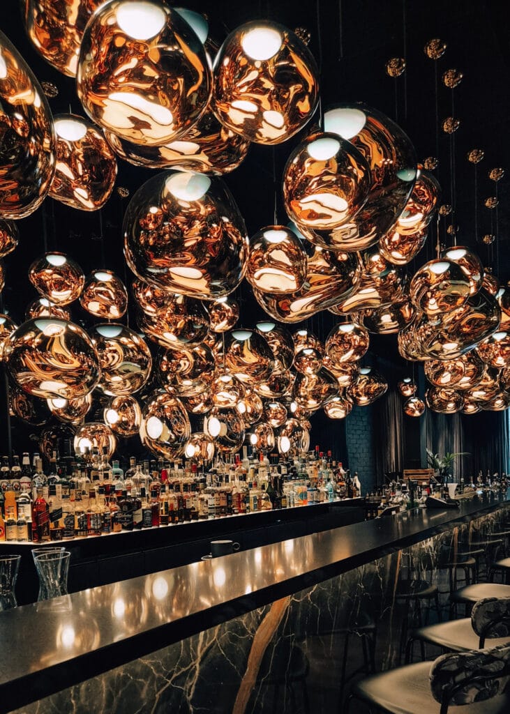 The bar at Cloud One Hotel in Gdansk, with lots of lamps designed as golden clouds hanging above.